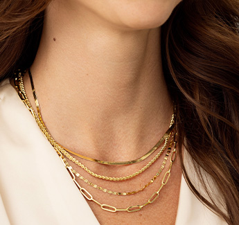 Closeup image of a woman wearing layered necklaces.